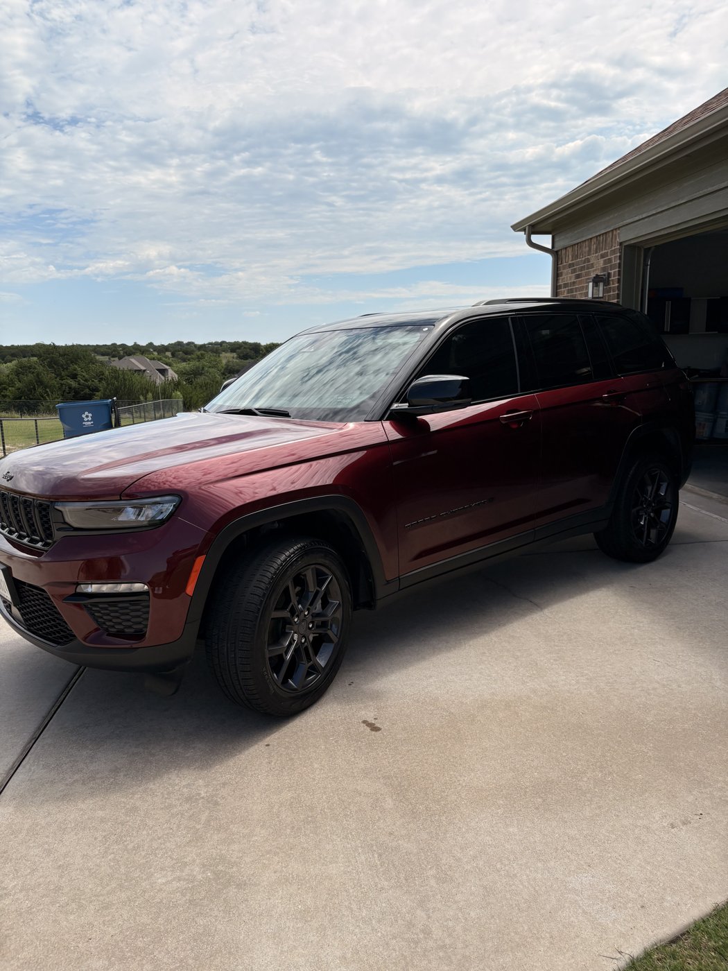 Maroon Jeep Grand Cherokee cleaned and shining in a driveway